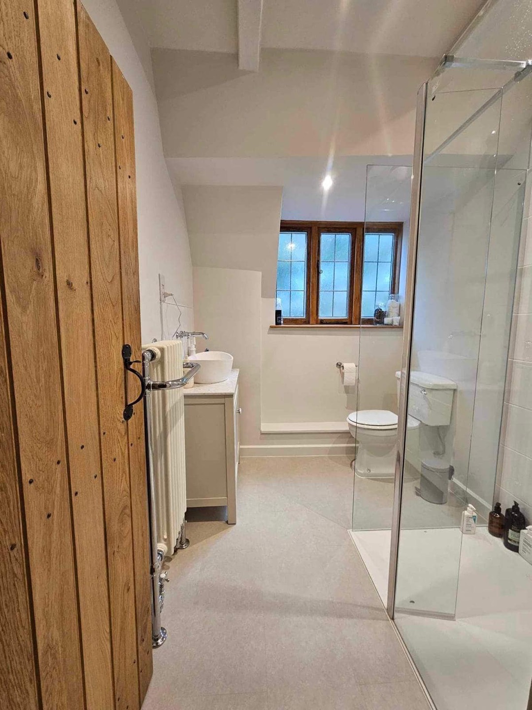 Modern bathroom with glass shower enclosure by Constructs in Cheltenham